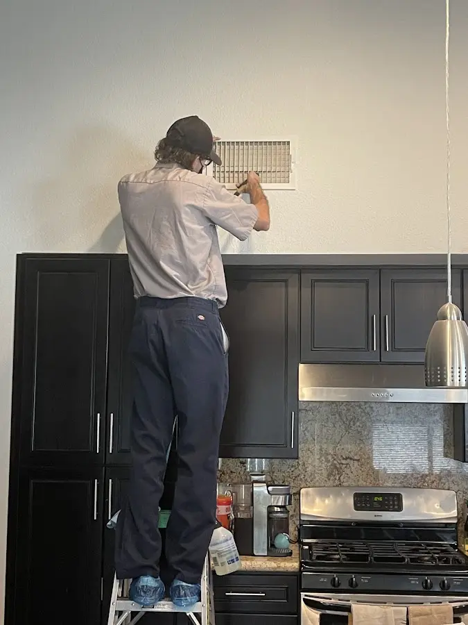 Technician inspecting an air vent during HVAC service in Thomaston